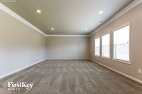 Flowery Branch house for rent - a empty living room with a carpeted floor and three windows