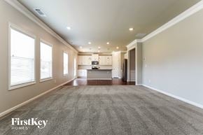Flowery Branch house for rent - an empty living room with a kitchen in the background