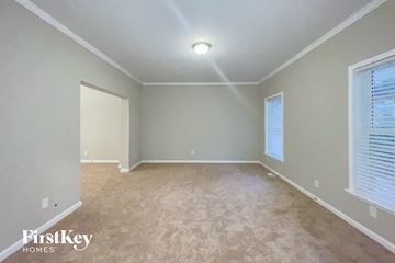 Dallas house for rent - the spacious living room with beige carpet and grey walls