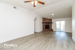 Mesa house for rent - A spacious room with a fireplace and a ceiling fan.