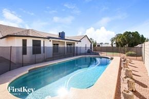 Mesa house for rent - A swimming pool in a backyard with a house in the background.