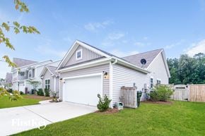 Moncks Corner house for rent - a white house with a white garage door and a green lawn