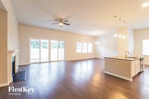 Moncks Corner house for rent - an empty living room with a kitchen and a ceiling fan