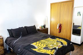 Ames apartment for rent - a bedroom with a bed with a yellow tiger blanket