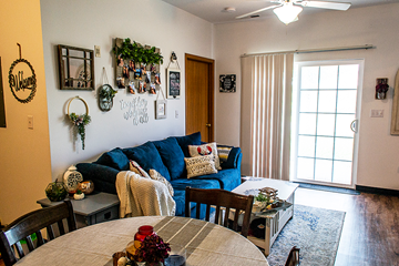Ames apartment for rent - a living room with a blue couch and a dining room table