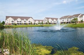 Ames apartment for rent - a pond with a fountain in front of some apartments