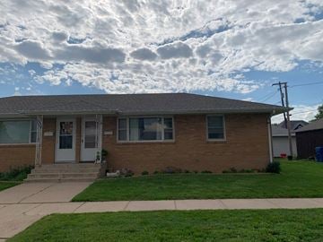 Kearney apartment for rent - a brick house with a cloudy sky in the background