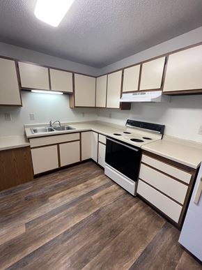 Rothschild apartment for rent - A kitchen with wooden floors and white cabinets.