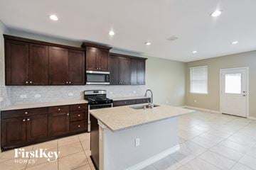 Converse house for rent - A kitchen with brown cabinets and a granite countertop.