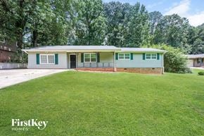 Douglasville house for rent - a blue and green house with a lawn and a driveway