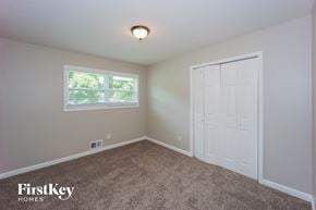 Douglasville house for rent - a bedroom with carpet and a white door and window