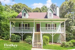 Canton house for rent - A green house with a porch and stairs leading to the front door.