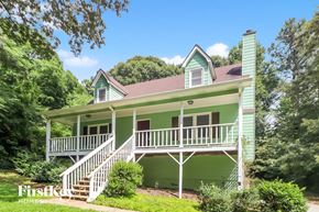 Canton house for rent - A green house with a porch and stairs leading to the front door.