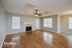 Covington house for rent - an empty living room with a fireplace and a ceiling fan