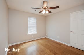Covington house for rent - a bedroom with wood floors and a ceiling fan