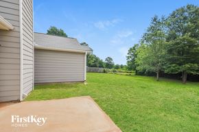 Covington house for rent - a backyard with a garage and a grassy area and a lawn