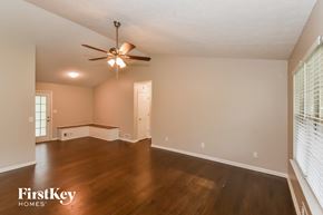 Dallas house for rent - an empty living room with wood floors and a ceiling fan