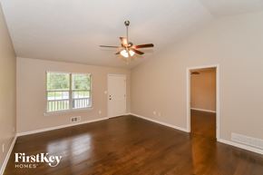 Dallas house for rent - an empty living room with wood floors and a ceiling fan