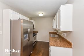 Dallas house for rent - a kitchen with white cabinets and a stainless steel refrigerator