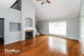 Cordova house for rent - A spacious living room with a fireplace and wooden floors.
