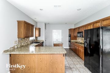 Cordova house for rent - A kitchen with wooden cabinets and a black refrigerator.