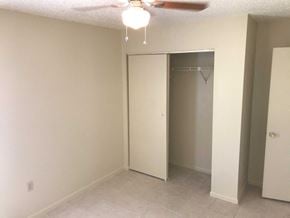 Bradenton house for rent - an empty bedroom with a closet and a ceiling fan