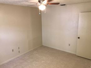 Bradenton house for rent - a living room with white walls and a ceiling fan