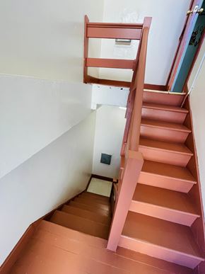 San Francisco apartment for rent - A brown wooden staircase with a white wall on the side.
