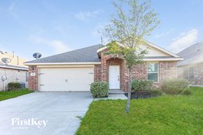 Royse City house for rent - a brick house with a white garage door and a tree