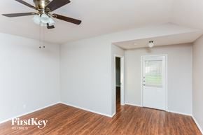 Royse City house for rent - a living room with a ceiling fan and a door to a hallway