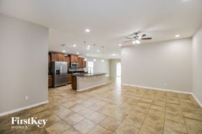 Jacksonville house for rent - an open kitchen and living room with tile flooring and stainless steel appliances