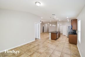 Jacksonville house for rent - a kitchen and living room with white walls and tile flooring