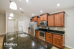 Jacksonville house for rent - a kitchen with granite counter tops and wooden cabinets and stainless steel appliances