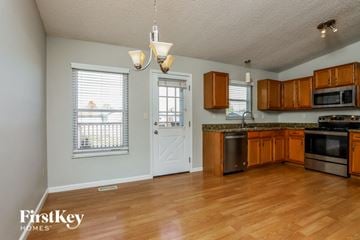 Arnold house for rent - A kitchen with wooden cabinets and a white door.