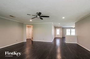 Magnolia house for rent - a living room with wood floors and a ceiling fan