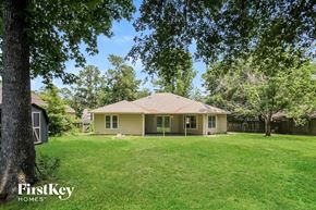 Magnolia house for rent - a yellow house sitting in the middle of a grassy yard