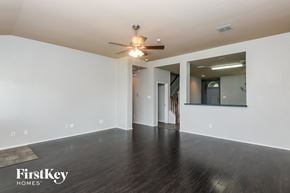 Grand Prairie house for rent - an empty living room with white walls and a ceiling fan