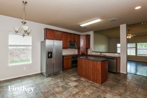 Grand Prairie house for rent - an empty kitchen with stainless steel appliances and wooden cabinets