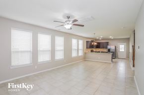Baytown house for rent - an empty living room and kitchen with a ceiling fan