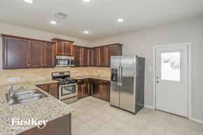 Baytown house for rent - a kitchen with wooden cabinets and stainless steel appliances