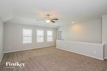 Baytown house for rent - a spacious living room with carpet and a ceiling fan