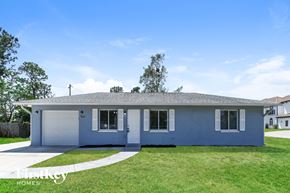 Fort Myers house for rent - A blue house with a white garage door and a driveway.