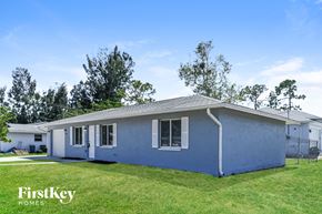 Fort Myers house for rent - A blue house with the words "FirstKey Homes" on the lawn.