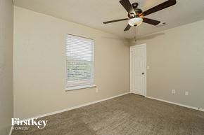 San Antonio house for rent - a bedroom with a ceiling fan and a door