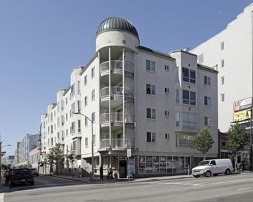 San Francisco apartment for rent - A white building with a green dome on top is situated on a street corner.