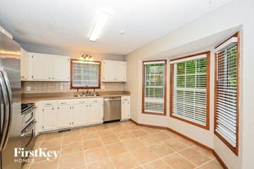 Acworth house for rent - a large kitchen with white cabinets and a sink