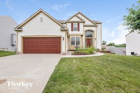 Kansas City house for rent - A house with a red garage door is for sale by FirstKey Homes.