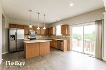 Kansas City house for rent - A kitchen with wooden cabinets and a refrigerator.