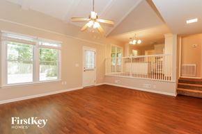 Summerville house for rent - A spacious living room with wooden floors and a staircase in the background.