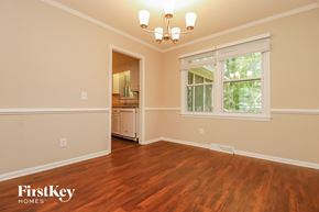 Summerville house for rent - A room with wooden floors and a window with a view of trees.